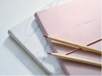 Open journal with pencils arranged neatly on a table