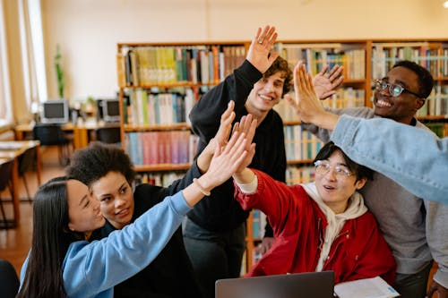 Group of college students giving a high five in class